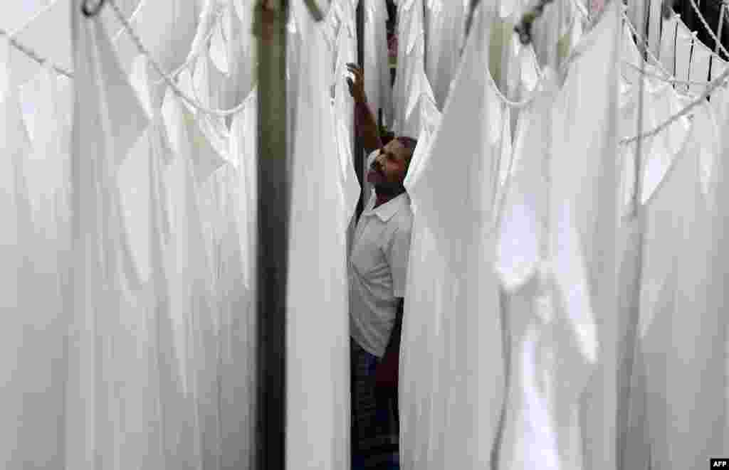 A laundry worker hangs freshly-washed sheets at one of the city's oldest laundry facilities, or 'dhobi ghats,' in Chennai, India.