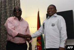 FILE - Mozambique’s President Filipe Nyusi, right, shakes hands with opposition leader Afonso Dhlakama in Maputo, Mozambique, Feb. 7, 2015.
