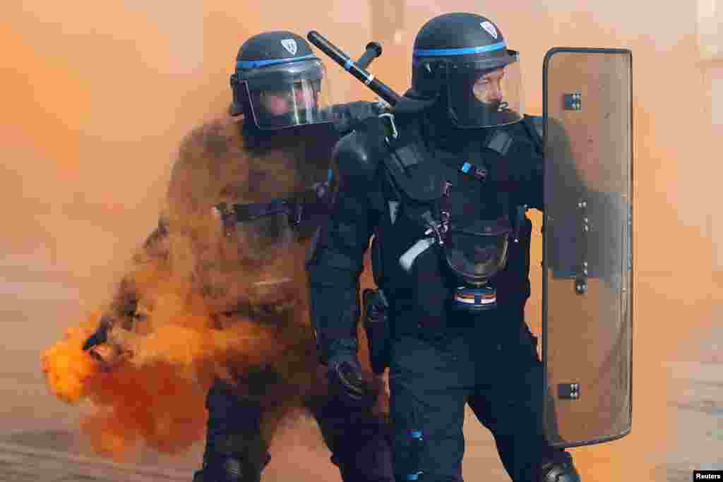 French CRS riot police face off with protesters during a demonstration against government reforms in Nantes.