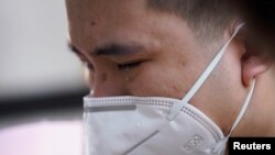 中国为死于冠状病毒病(COVID-19)的人举行全国哀悼活动，湖北省武汉市一名戴着口罩的男子哭泣。（2020年4月4日）
