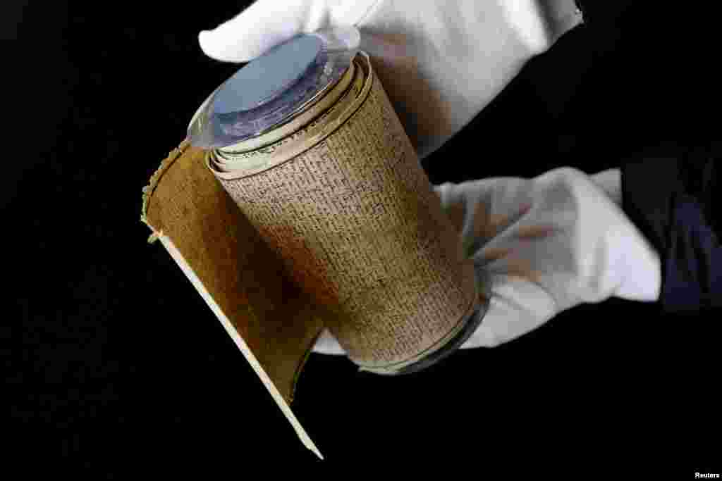 An employee displays the Marquis de Sade's original rolled manuscript called Le Rouleau de la Bastille of "Les 120 jours de Sodome ou l'ecole du libertinage" (The 120 Days of Sodom, or the School of Libertinage, 1785) before its auction at the Hotel Drouot auction house in Paris, France.