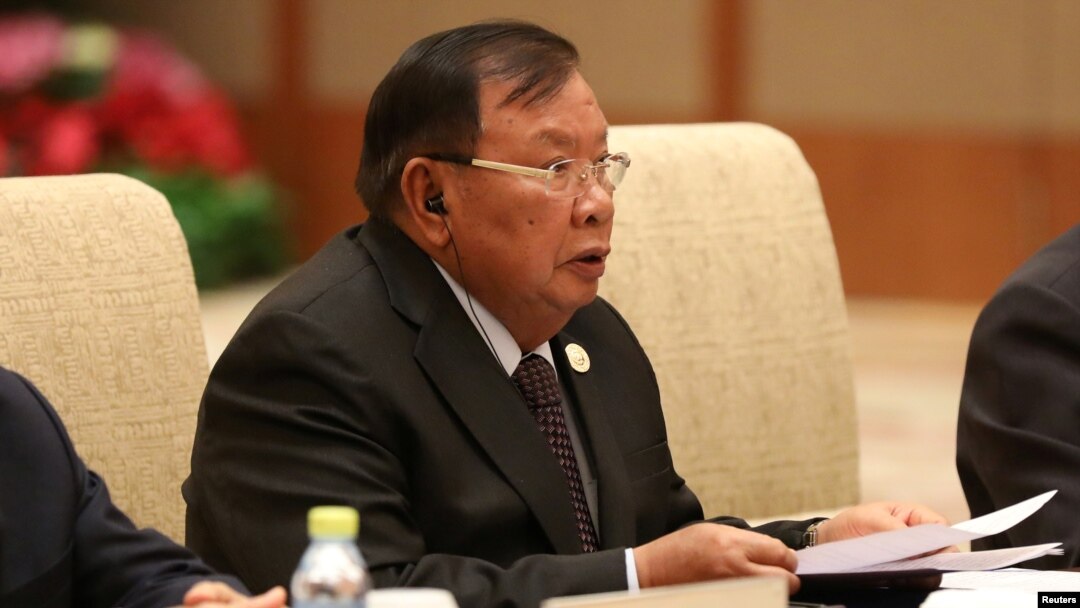 FILE - Laos' President Bounnhang Vorachith speaks with Chinese President Xi Jinping (not pictured) during a bilateral meeting at Diaoyutai State Guesthouse in Beijing, China.