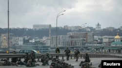 FILE - Servicemen of the Ukrainian National Guard take positions in central Kyiv, after Russia launched a massive military operation against Ukraine, Feb. 25, 2022.