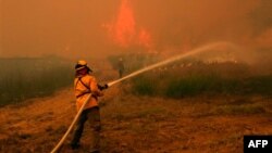 Nhân viên cứu hỏa từ khắp nơi ở Texas chiến đấu với đám cháy rừng trên đường cao tốc 71 gần Smithville ngày 5/9/2011