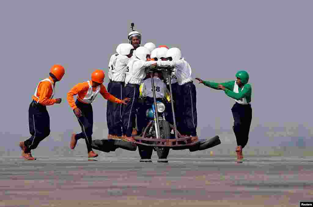 Members of Army Service Corps (ASC) "Tornadoes", the motorcycle display team of the Indian army, run to climb onto a motorcycle as they attempt to create a world record for most men on a single moving motorcycle at the Yelahanka Air Force Station in Bengaluru, India.
