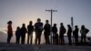FILE - Asylum-seeking migrants from Central America await transport after crossing the Rio Grande River into the United States from Mexico on a raft in Penitas, Texas, March 12, 2021. 