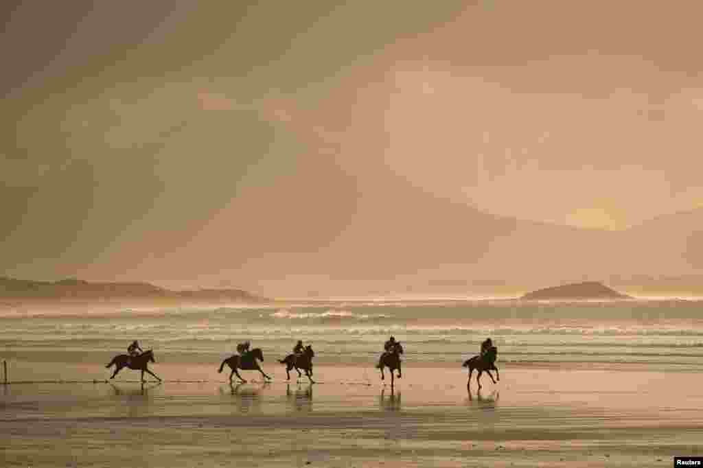 Runners and riders participate in the Christmas Ballyheigue beach horse races in the County Kerry village of Ballyheigue, Ireland.