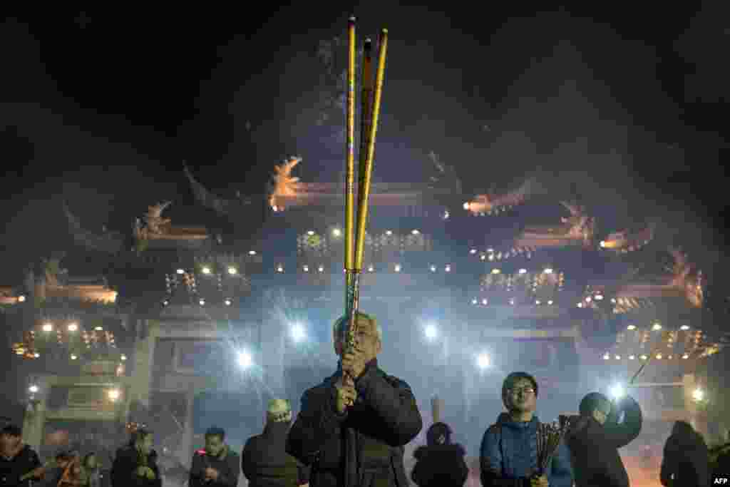 上海龙华寺内民众烧高香祈福，祈祷农历狗年平安顺意。照片拍摄于2018年2月15日。
