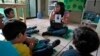 FILE - A teacher talks to children during class at a therapy and development center for autistic kids in Guatemala City.