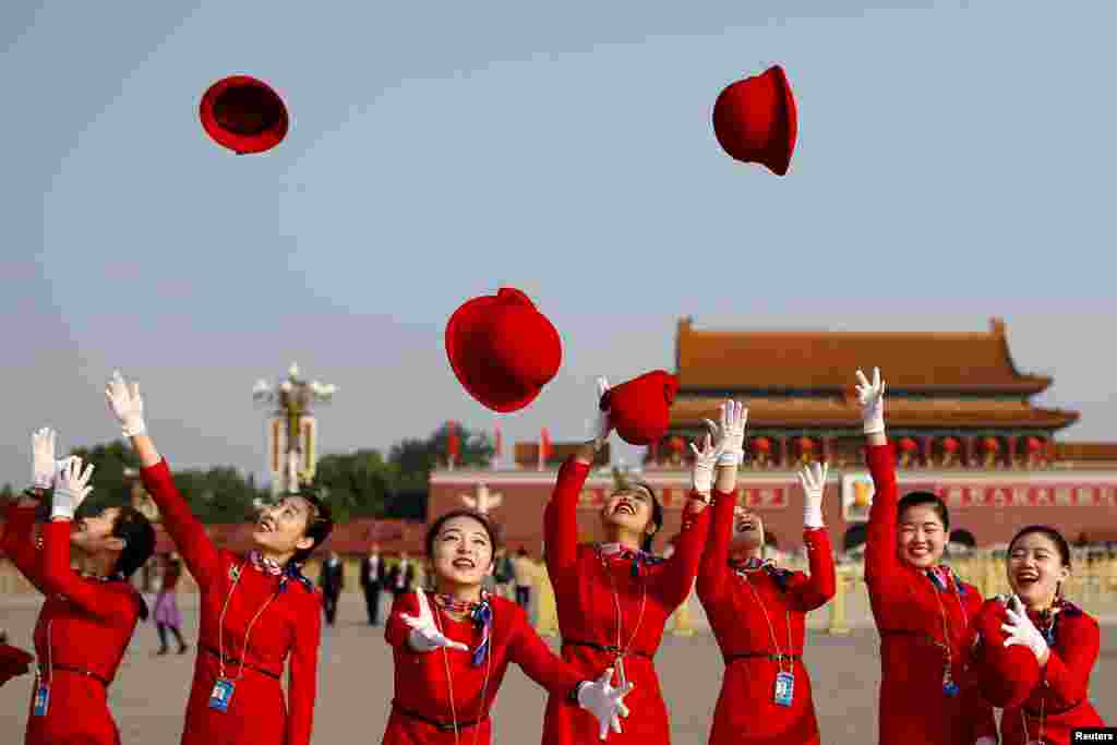 中国共产党第十九次全国代表大会闭幕式之前，接待员在天安门广场拍照（2017年10月18日）。美女接待员成为场外的亮丽风景，西方通讯社拍了一些照片。