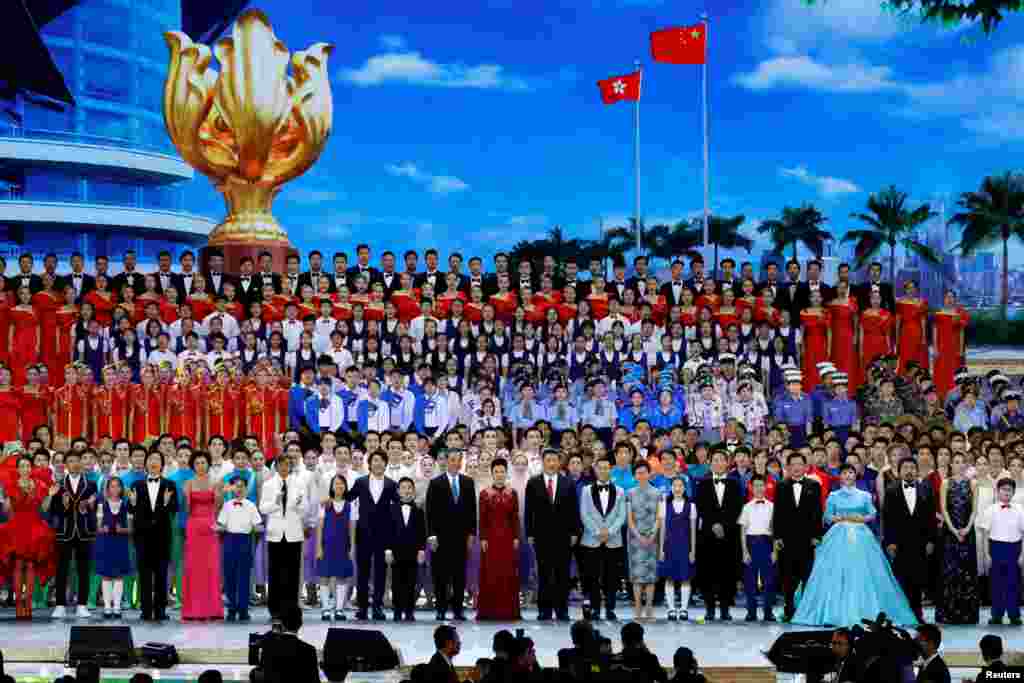 在维多利亚港的香港会展中心举行的庆祝香港主权移交中国20周年的文艺晚会上,中国最高领导人习近平以及香港特首梁振英和当选特首林郑月娥等人和演员们一起歌唱(2017年6月30日)。