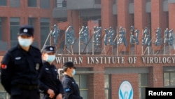 在世卫组织新冠病毒源头调查组视察武汉的中国科学院病毒研究所期间，中国保安人员在研究所外站岗。 （路透社 2021年2月3日）