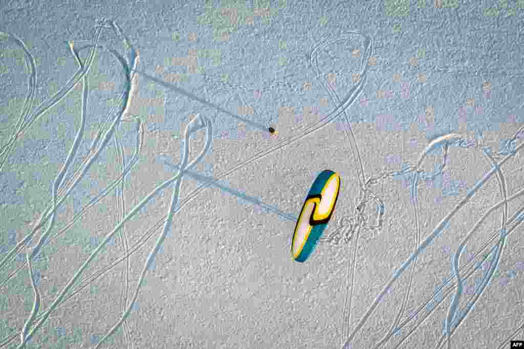 A paraglider has a land-based practice session on snow near Semsales, western Switzerland, Dec. 3, 2017.
