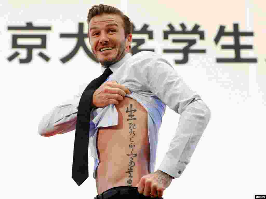 Beckham shows his tattoo after he was asked to by students at Peking University during his visit to Beijing March 24, 2013. The tattoo in Chinese characters reads, "Life and death are determined by fate, rank and riches decreed by Heaven."