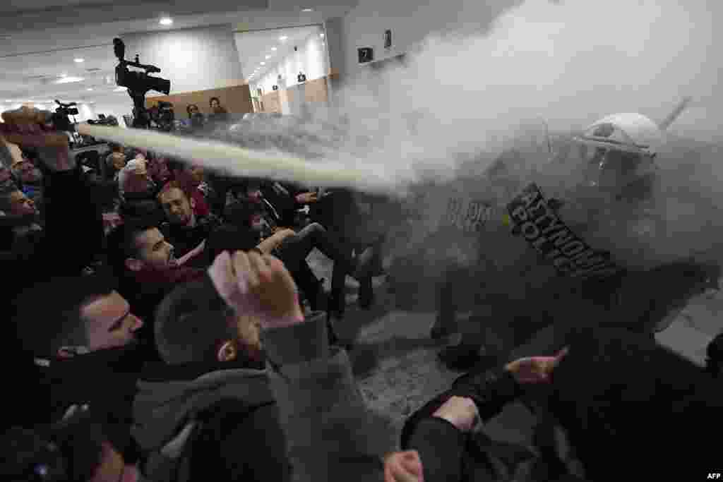 People protesting homes' auctions clash with riot police at Athens court of appeals as foreclosures begin anew as part of reforms under Greece's bailout plans.