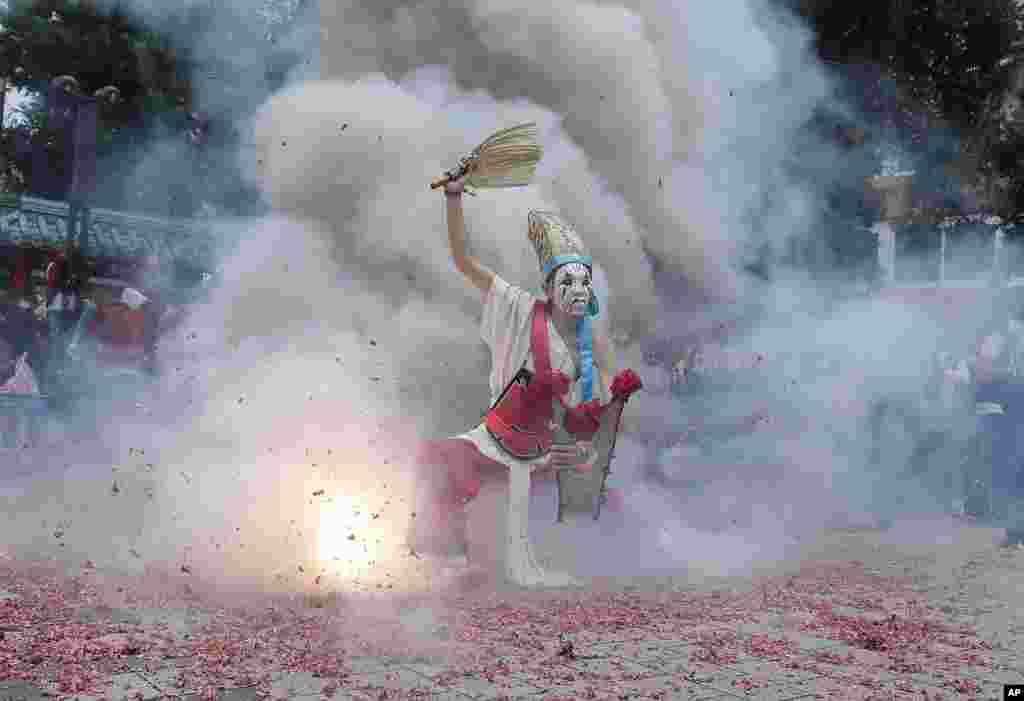 A participant dressed as Ba Jia Jiang, a Chinese guardian of the gods, is purified by firecrackers during a temple festival marking the birthday of traditional Taoist deity "Qingshan Wang" or "Ling''an Zunwang" in Taipei, Taiwan. (AP Photo/Chiang Ying-ying)