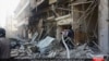 In this Oct. 5, 2015 photo released by the Rased News Network, a Facebook account affiliated with Islamic State militants, which has been authenticated based on its contents and other AP reporting, people gather at the site of an airstrike in Al-Bab on th