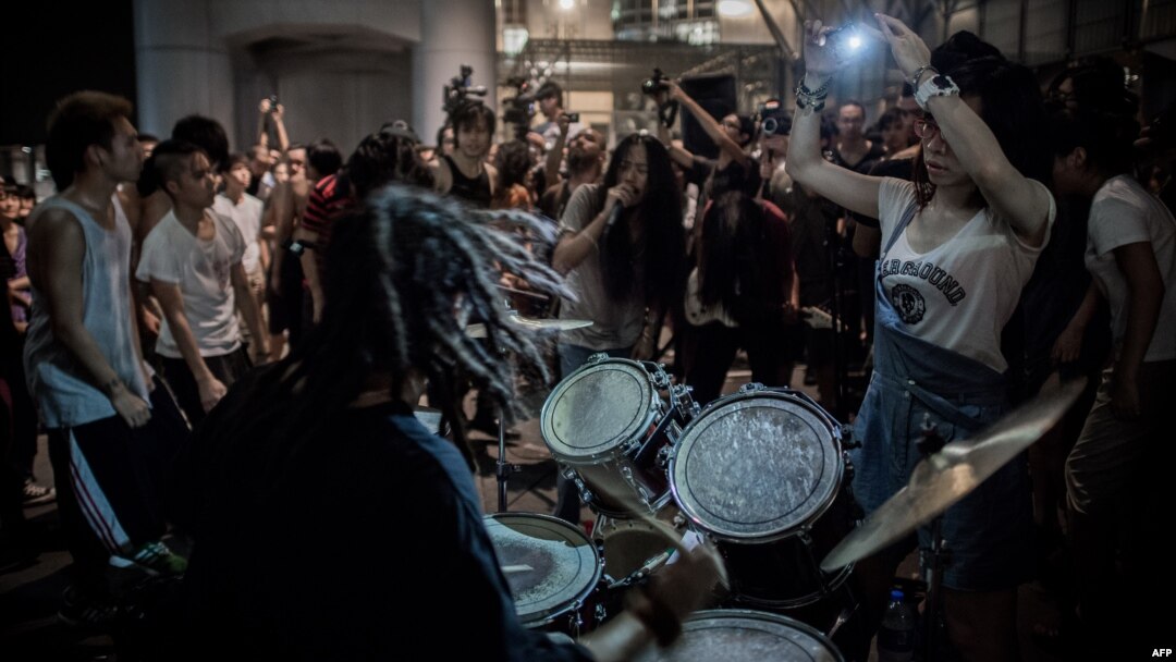Protesters give a concert at the "Occupy" movement campsite area outside the HSBC bank headquarters in Hong Kong on August 27, 2012.
