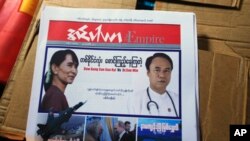 Ảnh của bà Aung San Suu Kyi và ông Soe Min, đối thủ của bà trong cuộc tranh cử, trên trang đầu của một nhật báo của Miến Điện
