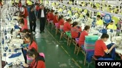 资料照：中国新疆和田一所职业教育训练中心的穆斯林学员在服装厂里工作。(2019年1月9日)